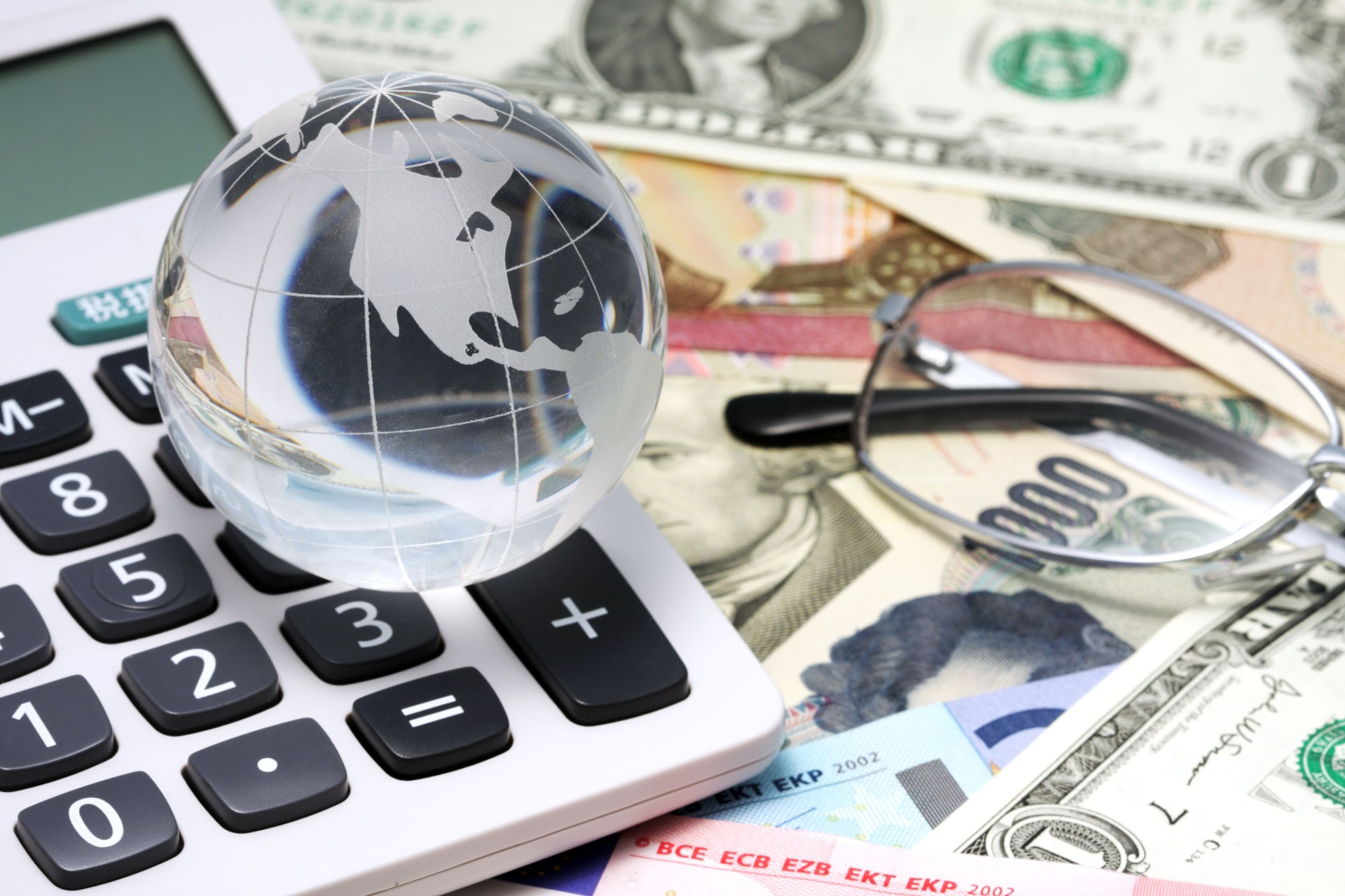 Business concept with calculator, glasses and globe